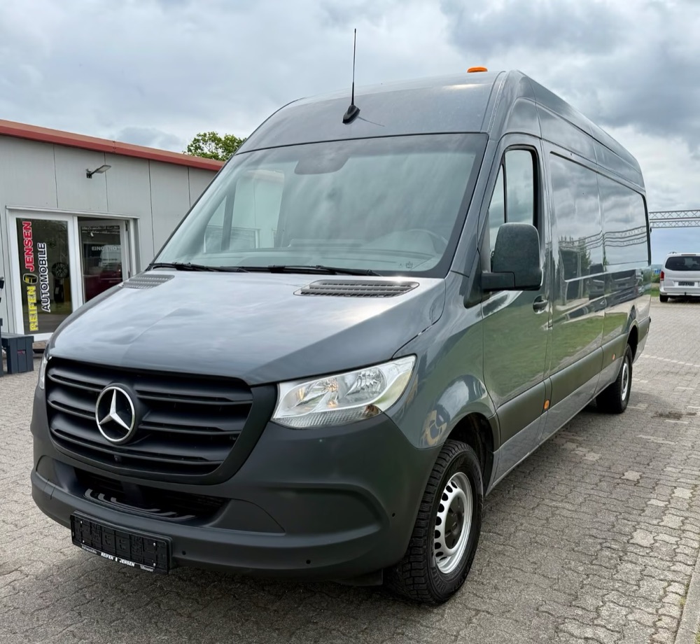 Mercedes-Benz Sprinter gri, văzut din față, cu parbrizul și locul șoferului